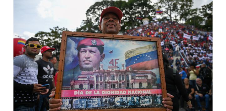 Un partidario del presidente de Venezuela, Nicolás Maduro, sostiene una imagen del fallecido presidente venezolano Hugo Chávez y asiste a una concentración para conmemorar el 65 aniversario de la Insurrección Popular de 1958 a lo largo de la céntrica avenida Sucre, en Caracas.