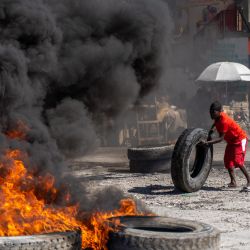 Un manifestante añade un neumático a una barricada en llamas durante una manifestación policial para protestar por los recientes asesinatos de seis policías a manos de bandas armadas, en Puerto Príncipe, Haití. | Foto:Richard Pierrin / AFP