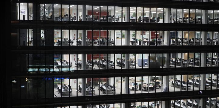 Esta fotografía muestra oficinas vacías en espacios abiertos con las luces aún encendidas después del horario de oficina, en Madrid, España.