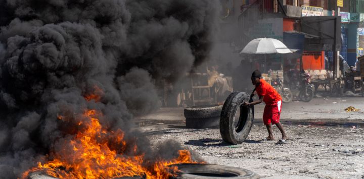 Un manifestante añade un neumático a una barricada en llamas durante una manifestación policial para protestar por los recientes asesinatos de seis policías a manos de bandas armadas, en Puerto Príncipe, Haití.