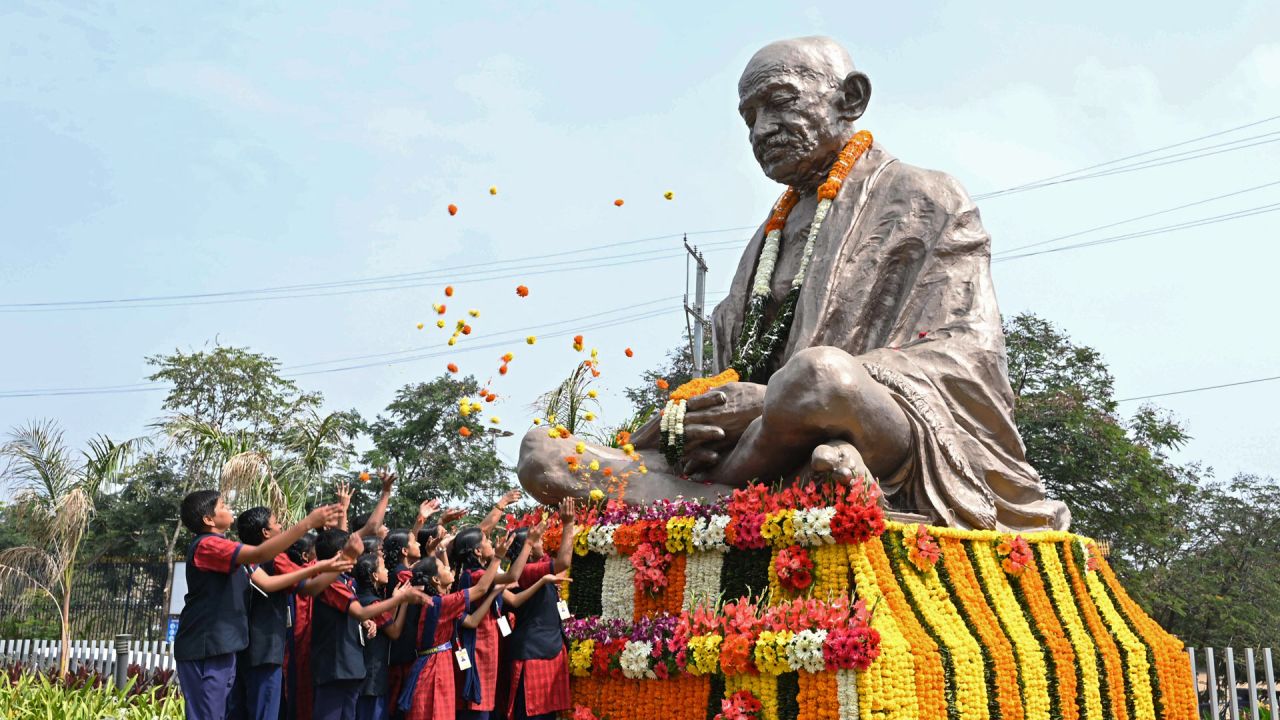 Alumnos esparcen flores sobre la estatua de Mahatma Gandhi en el aniversario de su muerte, en Hyderabad. - El aniversario de la muerte de Gandhi, conocido en la India como Bapu (padre), también se celebra en el país como el Día del Mártir. | Foto:NOAH SEELAM / AFP
