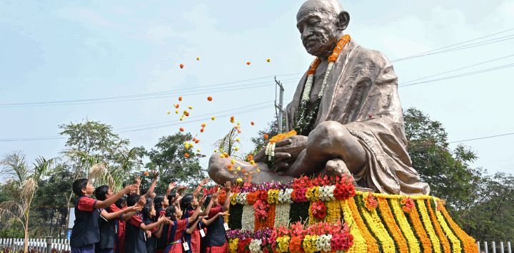 Alumnos esparcen flores sobre la estatua de Mahatma Gandhi en el aniversario de su muerte, en Hyderabad. - El aniversario de la muerte de Gandhi, conocido en la India como Bapu (padre), también se celebra en el país como el Día del Mártir.