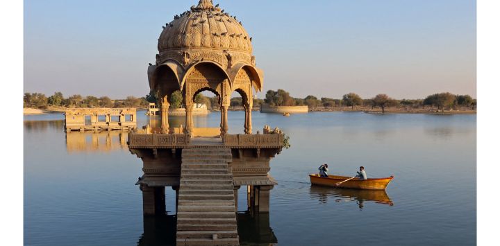 En esta fotografía unos visitantes contemplan un edificio en el lago Gadisar, en Jaisalmer, en el desértico estado indio de Rajastán.