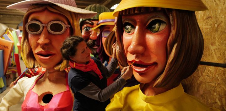 Una artista utiliza un pincel mientras trabaja en las figuras que representan a Brigitte Macron, la esposa del presidente francés, durante los preparativos de las carrozas para el próximo Carnaval de Niza.