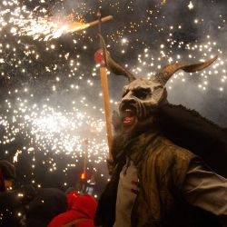 Un participante con una máscara de demonio blande un palo con fuegos artificiales entre los juerguistas durante la tradicional fiesta del Correfoc en Palma de Mallorca. | Foto:JAIME REINA / AFP