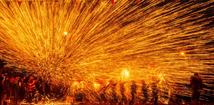 Imagen de artistas folclóricos interpretando "flores de hierro", un espectáculo en el que se lanza hierro fundido para crear fuegos artificiales, en celebración del próximo Festival de las Linternas, en el municipio de Goujiang del distrito de Bozhou, en el suroeste de China.
