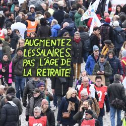 Un manifestante sostiene una pancarta en la que se lee "Aumentar los salarios, no la edad de jubilación" en el segundo día de huelgas y protestas en todo el país por la reforma de las pensiones propuesta por el Gobierno, en París. | Foto:ALAIN JOCARD / AFP