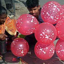 Una mujer se prepara para vender globos a los viajeros en un cruce de carreteras en Amritsar, India. | Foto:Narinder Nanu / AFP