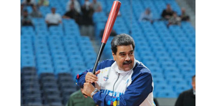 Esta foto muestra al presidente venezolano Nicolás Maduro bateando la pelota en el Estadio Monumental Simón Bolívar de Caracas, antes de la Serie del Caribe de Béisbol.