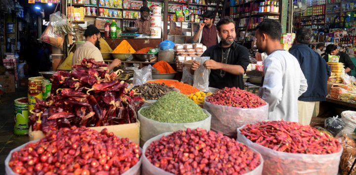 Esta fotografía muestra a unos residentes comprando alimentos en un mercado de Karachi, ciudad portuaria de Pakistán.