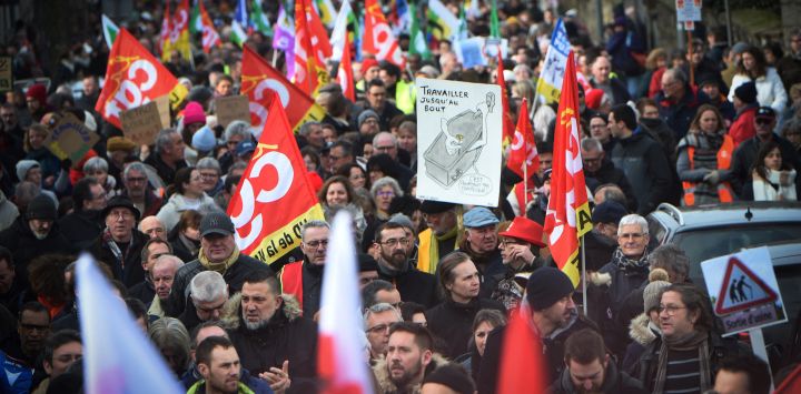 Manifestantes ondean banderas sindicales y pancartas mientras marchan durante una manifestación como parte de una jornada nacional de huelgas y concentraciones por segunda vez en un mes, para protestar contra una reforma prevista para aumentar la edad de jubilación de 62 a 64 años, en Laval, oeste de Francia.