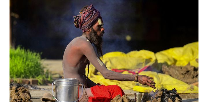 Un sadhu u hombre santo realiza un ritual en Sangam, la confluencia de los ríos Ganges, Yamuna y el mítico Saraswati, durante la feria religiosa anual de Magh Mela en Prayagraj, India.