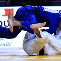 El francés Walide Khyar y el kazajo Gusman Kyrgyzbayev (azul) compiten durante su combate masculino de -66kg en la tercera ronda del torneo de judo Grand Slam de París. | Foto:Anne-Christine Poujoulat / AFP