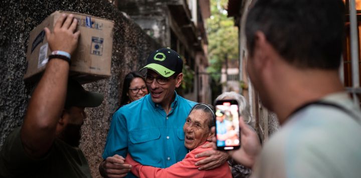 El líder de la oposición venezolana, Henrique Capriles, abraza a un simpatizante mientras camina por las calles como parte de una campaña para entregar medicinas a adultos mayores en Guarenas, estado Miranda, Venezuela.