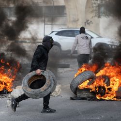 Manifestantes palestinos queman neumáticos para bloquear una carretera que conduce a Jericó, en la Cisjordania ocupada, tras una redada de las fuerzas israelíes en la ciudad. | Foto:AHMAD GHARABLI / AFP