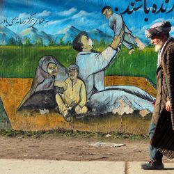 Un hombre afgano pasa junto a un mural en el distrito de Fayzabad, en la provincia de Badakhshan. | Foto:OMER ABRAR / AFP