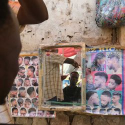 Un barbero callejero afeita el pelo a su cliente en Juba, Sudán del Sur. | Foto:Simon Maina / AFP