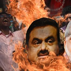 Un activista del partido del Congreso de la India grita consignas mientras quema una efigie del primer ministro Narendra Modi y del magnate indio Gautam Adani durante una concentración organizada para protestar contra las políticas financieras del gobierno de la unión en Calcuta, India. | Foto:DIBYANGSHU SARKAR / AFP
