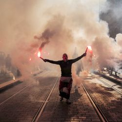 Manifestantes con bengalas de humo en la mano participan en una manifestación en el tercer día de concentraciones nacionales organizadas desde principios de año contra la impopular reforma de las pensiones en Niza, sureste de Francia. | Foto:VALERY HACHE / AFP
