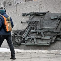 Un peatón pasa junto al monumento a Mijaíl Kaláshnikov, inventor del fusil de asalto AK-47, en el centro de Moscú, Rusia. | Foto:YURI KADOBNOV / AFP