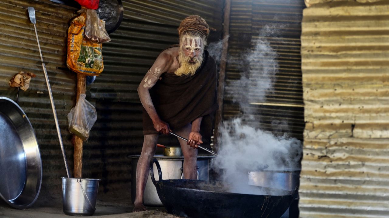Un sadhu u hombre santo hindú prepara comida dentro de un campamento durante la feria religiosa anual de Magh Mela en Sangam, la confluencia de los ríos Ganges, Yamuna y el mítico Saraswati en Prayagraj, India. | Foto:SANJAY KANOJIA / AFP