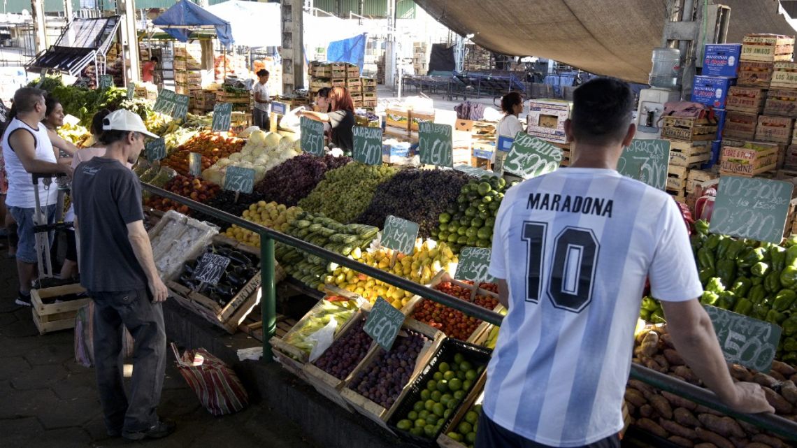People buy fruits and vegetables at a retail stall at a market in Buenos Aires on February 10, 2023, some days before the announcement of the monthly inflation index. 
