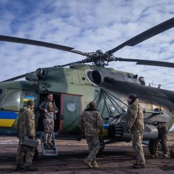 Miembros de la tripulación de un helicóptero de la 18ª Brigada de Aviación Separada del Ejército se preparan antes de un despegue, en el este de Ucrania, en medio de la invasión militar rusa sobre Ucrania. | Foto:IHOR TKACHOV / AFP