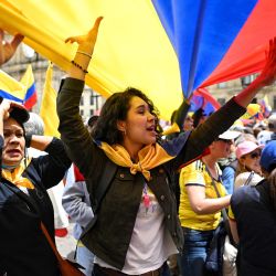 Opositores al presidente colombiano Gustavo Petro sostienen una gran bandera nacional mientras participan en una manifestación contra las reformas del Gobierno en Bogotá. | Foto:JUAN BARRETO / AFP