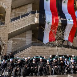 Residentes drusos de los Altos del Golán posan juntos bajo gigantescas banderas sirias colgadas en la fachada de un edificio mientras se reúnen para una manifestación contra la ley de anexión israelí de 1981 de la estratégica meseta que el Estado judío capturó de Siria durante la guerra árabe-israelí de 1967, en el pueblo druso de Majdal Shams en los Altos del Golán anexionados por Israel. | Foto:JALAA MAREY / AFP
