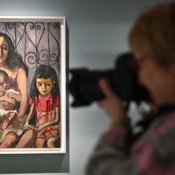Un fotógrafo trabaja cerca de una obra de arte titulada 'The Spanish Family, 1943' de la artista estadounidense Alice Neel durante un avance de prensa de 'Alice Neel: Hot Off The Griddle' en la Barbican Art Gallery de Londres. | Foto:JUSTIN TALLIS / AFP