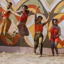 Un grupo de danza actúa delante de un muro decorado durante el Festival Bogoia en Siby. | Foto:OUSMANE MAKAVELI / AFP