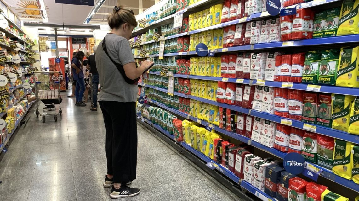 Monica Schenone, a member of the 'Movimiento a la Dignidad' (Movement for Dignity) checks the prices of the "Precios Justos" programme, at a supermarket in Buenos Aires on February 9, 2023. 