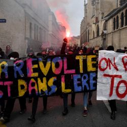 Estudiantes sostienen una pancarta en la que se lee "Esta es la era de la revuelta" durante una concentración de camino al punto de encuentro de la manifestación contra la reforma de las pensiones prevista por el Gobierno en París, Francia. | Foto:JULIEN DE ROSA / AFP
