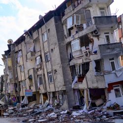 Un residente local pasa por delante de un edificio destruido en Hatay, Turquía, tras el terremoto de magnitud 7,8 que sacudió el sureste del país. | Foto:YASIN AKGUL / AFP