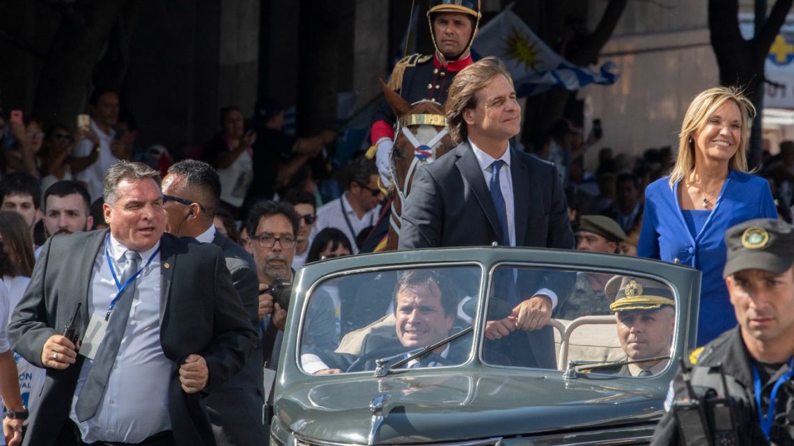 In this file photo taken on March 1, 2020 Former Chief of the Presidential guard, Alejandro Astesiano (L), runs next to Uruguay's President Luis Lacalle Pou (C) and Vice President Beatriz Argimon (R) during the inauguration ceremony in Montevideo.