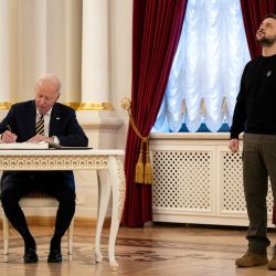 El presidente Joe Biden firma en el libro de visitas durante una reunión con el presidente ucraniano Volodymyr Zelensky en el Palacio Mariinsky de Kiev. | Foto:Evan Vucci / POOL / AFP
