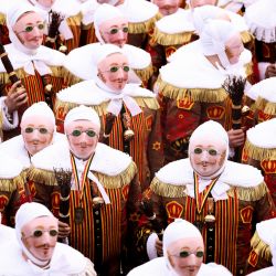 Personas disfrazados de "Gilles", los participantes más antiguos y principales del Carnaval de Binche en Bélgica, participan en el desfile en Binche. | Foto:KENZO TRIBOUILLARD / AFP