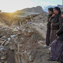 Esta fotografía muestra a unas mujeres sobre los escombros de su casa derrumbada en el pueblo de Yaylakonak, en el distrito de Adiyaman, un pueblo de la comunidad kurda aleví donde murieron 108 personas y 170 casas se derrumbaron tras un terremoto de magnitud 7,8 que sacudió partes de Turquía y Siria. | Foto:BULENT KILIC / AFP