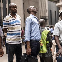 Un grupo de personas espera dinero en la puerta de un banco en Lagos. - Nigeria se ha visto afectada por la escasez de efectivo después de que el banco central empezara a canjear los antiguos billetes de naira por billetes nuevos. | Foto:JOHN WESSELS / AFP
