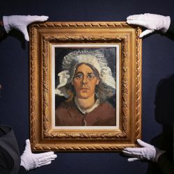 Asistentes de la galería retienen "Cabeza de mujer", del pintor holandés Vincent Van Gogh, en la casa de subastas Christie's antes de la "20th/21st Century Evening Sale", que se celebrará en Londres. | Foto:DANIEL LEAL / AFP