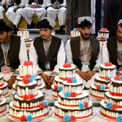 Novios afganos asisten a su ceremonia de boda masiva en un salón en Kandahar. | Foto:Sanaullah Seiam / AFP