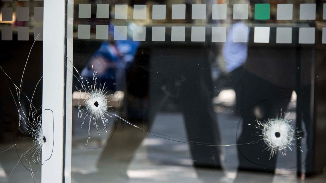 Picture of bullet holes in a window of a supermarket belonging to the family of Antonela Roccuzzo, the wife of Lionel Messi, after attackers fired shots at the façade of the closed premises early in the morning and left a threatening message, in Rosario, Santa Fe Province, on March 2, 2023. 
