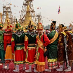 Personas vestidas con ropas religiosas tradicionales se reúnen para una ceremonia budista en la que se coloca un paraguas dorado auspicioso en lo alto de una pagoda, donado por el jefe de las Fuerzas de la Guardia de Fronteras del estado de Karen, Saw Chit Thu, en la pagoda Pyi Thar Lin Aye, en Myanmar. | Foto:AFP