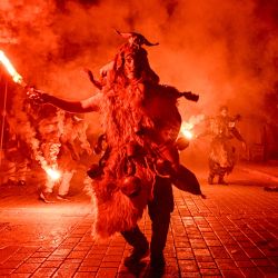Una persona disfrazada enciende una bengala durante una procesión que marca una celebración tradicional de carnaval en la ciudad de Amfissa, en el centro de Grecia. | Foto:LOUISA GOULIAMAKI / AFP