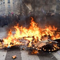 Manifestantes pasan junto a una hoguera durante una manifestación, en el marco de una jornada nacional de huelgas y protestas convocada por los sindicatos por la propuesta de revisión de las pensiones, en París, Francia. | Foto:EMMANUEL DUNAND / AFP