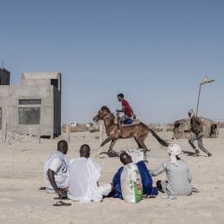 Unos hombres montan a caballo mientras disfrutan de una tarde en una popular playa del distrito de Tefargh Zeina, en Nuakchot, Mauritania. | Foto:MARCO LONGARI / AFP