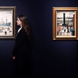 Dos asistentes de la galería posan junto a dos pinturas del artista británico Laurence Stephen Lowry llamadas "Glasgow Docks" y "The Clock Tower" en la casa de subastas Christie's en Londres, antes de la "Venta nocturna de arte moderno británico e irlandés". | Foto:JUSTIN TALLIS / AFP