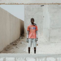 Husseinu, de 20 años, de Dakar, Senegal, trabajando en una obra en las afueras de Nuakchot, posa para un retrato. | Foto:MARCO LONGARI / AFP