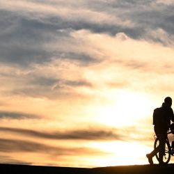 Un ciclista camina con su bicicleta mientras se pone el sol en el parque olímpico de Múnich, sur de Alemania. | Foto:Christof Stache / AFP