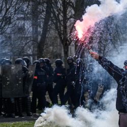 Un manifestante sostiene una bengala frente a la policía antidisturbios durante una manifestación en el octavo día de huelgas y protestas en todo el país contra la reforma de las pensiones propuesta por el gobierno, en Nantes, Francia. | Foto:LOIC VENANCE / AFP